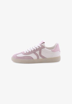 Witte en lichtroze lage sneaker met suède overlays, witte veters en een beige rubberen zool, getoond vanaf de buitenkant op een witte achtergrond.