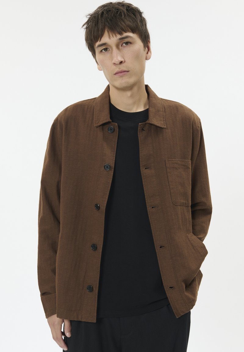 Mladic u smešnom smešku s smeškom u smešnom smešku na svetnoj pozadini.