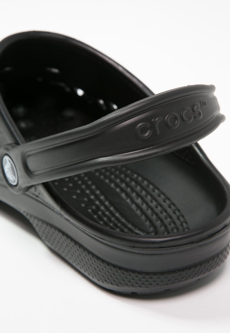 Sandalia Crocs negra que presenta una correa con detalles del logo, plantilla texturizada y lados perforados para mejorar la transpirabilidad. Diseño ligero y moldeado.