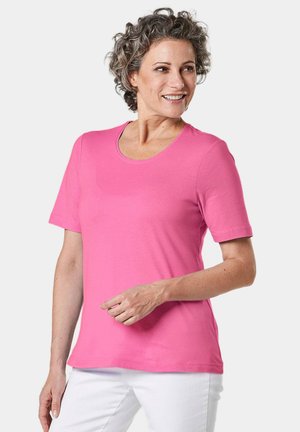 T-shirt a maniche corte con scollatura a barca di un vivace colore rosa, realizzato in tessuto morbido. Presenta una vestibilità ampia e una consistenza liscia. Nessun motivo o dettaglio particolare.
