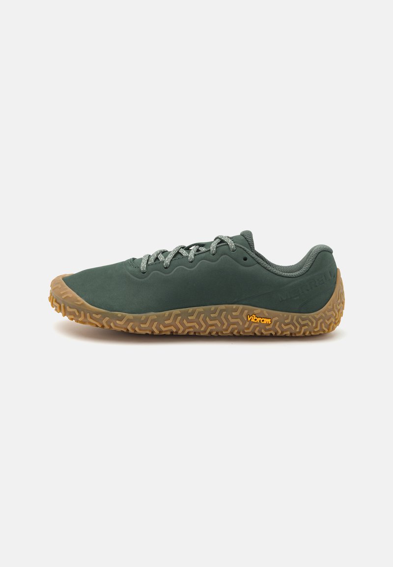 Scarpa verde in suede con suola Vibram marrone testurizzata, lacci grigi e design a profilo basso. Presenta accenti stampati sulla parte superiore.