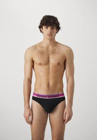 Črne bikini hlačke z roza in vijoličnim pasom, na katerem je črno napisano ime blagovne znamke "bruno banani". Gladek, prilegajoč se dizajn.