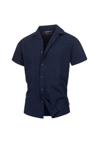 Camicia button-up a maniche corte blu navy con colletto, leggermente aperta, che mostra la texture del tessuto di cotone e l'etichetta interna.
