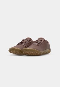 Chaussures brunes avec un dessus texturé, présentant un design à lacets, une semelle flexible et un motif de bande de roulement robuste pour une adhérence améliorée.
