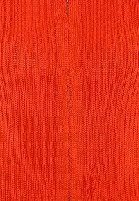 Pletený kardig�án v jasne oranžovej farbe, s rebrovanou textúrou, otvoreným predným dizajnom a hladkým povrchom bez ozdôb.