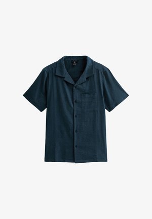 Chemise à manches courtes boutonnée en tissu bleu foncé, avec un motif texturé, une poche poitrine et un col classique.
