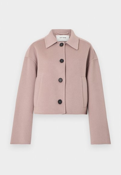 Ελαφρύ βελούδινο μπουφάν σε μωβ ανοιχτή απόχρωση, κοντό μήκος, με μακριά μανίκια, μαύρα κουμπιά στο μπροστινό μέρος, πλαϊνές τσέπες και μυτερό γιακά.