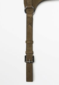 Ceinture en daim vert olive avec boucle et anneau en argent, bords cousus, et deux passants, sur fond blanc uni.