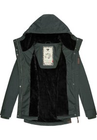 Giacca esterna verde con rivestimento interno in morbido pellicciotto nero, cappuccio e chiusura a bottoni. Etichetta con design floreale visibile all'interno.