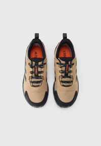 Bézs színű kültéri cipők fekete részletekkel, struktúrált felsőrész, lapos fűzők kék kiemelésekkel és gumi talpakkal, narancssárga „TERREX” felirattal.