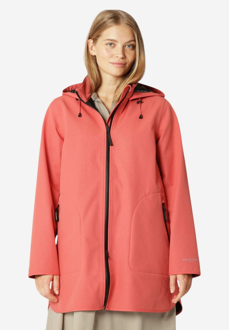 Chaqueta impermeable color coral con capucha, con cierre de cremallera, grandes bolsillos laterales y acentos en negro. Fabricada con un tejido liso y texturizado.