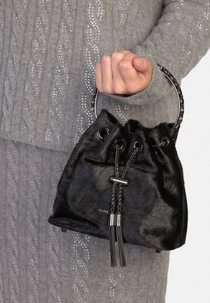 Bolso tipo cubo de piel sintética negra con cierre de cordón y detalles metálicos. Cuenta con un asa circular y borlas colgantes.