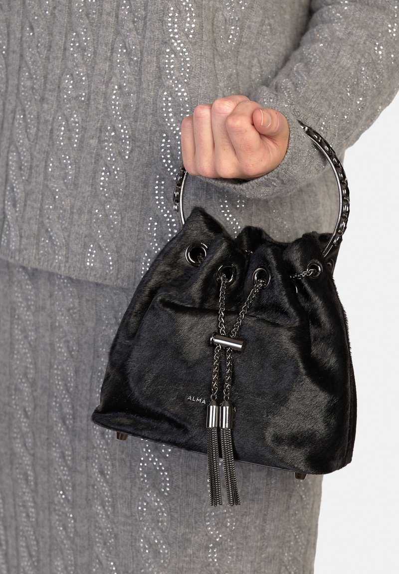 Borsa a secchiello in ecopelliccia nera con chiusura a coulisse e dettagli metallici. Presenta un manico circolare e nappe pendenti.