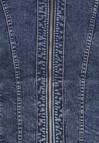 Chaqueta de mezclilla con cierre central de cremallera, fabricada en tejido azul oscuro, costuras texturizadas y costura contrastante a lo largo de la solapa y los bordes.