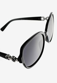 Gafas de sol grandes y negras con lentes grises, que presentan un acabado brillante, brazos robustos y detalles en plata cerca de la patilla.