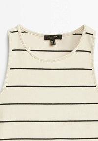 Débardeur côtelé crème avec des rayures horizontales noires. Il présente un col rond et de larges bretelles. Étiquette visible avec les instructions d'entretien.