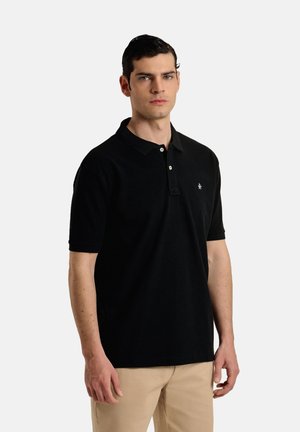 Camisa polo negra hecha de tela suave, con un cuello con solapa, una tapeta de tres botones y un pequeño logo en el pecho.