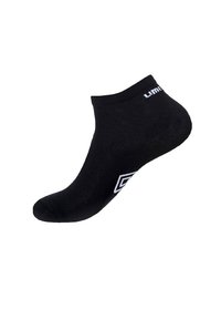 Chaussette noire jusqu'à la cheville avec bord côtelé, fabriquée en tissu doux, présentant un logo de marque blanc à l'extérieur et une forme épurée et profilée.