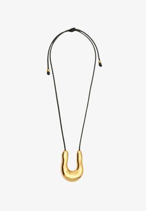 Kultaisten sävyjen riipuskaulaketju, jossa on U-muotoinen muotoilu, roikkuu mustassa narussa. Riipuksessa on sileä, kiiltävä pinta.