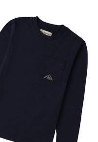 T-shirt a maniche lunghe color navy in cotone, con taschino frontale e una toppa a forma di triangolo. Texture liscia, design a girocollo.