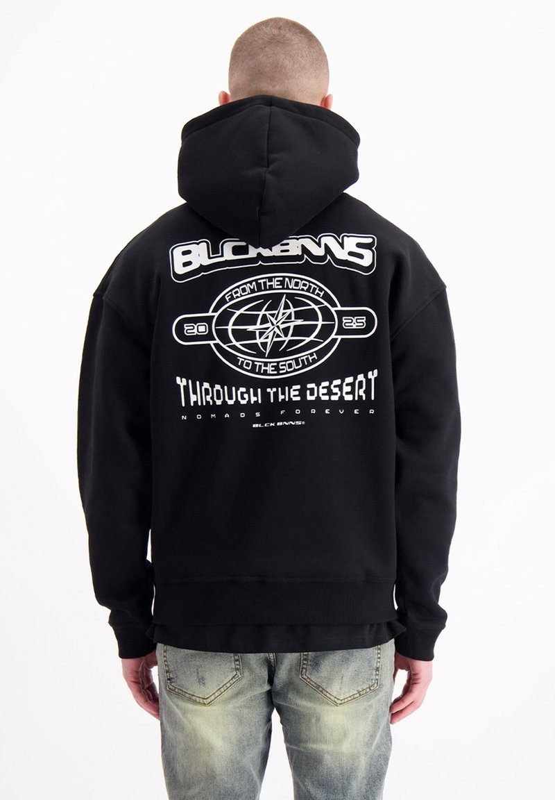 Zwarte hoodie met een grote witte grafische opdruk op de rug, featuring tekst en een kompasontwerp, gemaakt van zachte, gestructureerde stof.
