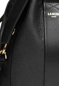 Sac à main en cuir noir avec une surface texturée, des éléments en métal doré, une forme structurée et des détails de couture contrastants.