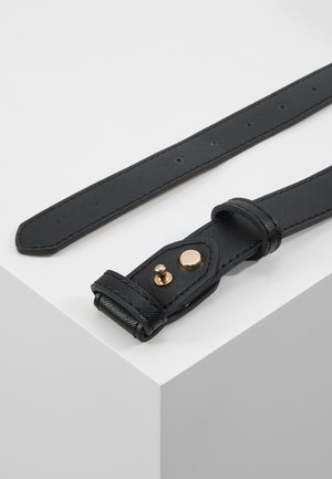 Zwarte leren riem met gestructureerde afwerking, gouden knoop- en gespsluiting, en meerdere verstelgaten op een witte ondergrond.