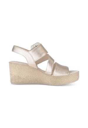 Beige wedge sandal with three metallic straps and a woven texture platform heel on a white background.