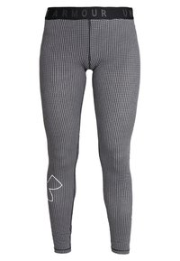 Mustat ja valkoiset kuviolliset legginsit, joissa on leveä musta vyötärönauha, yksityiskohtana valkoinen logo ja geometrinen kuosi kankaalla.