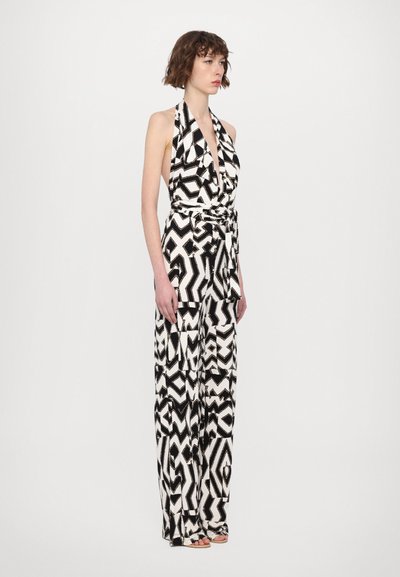 Zwart-witte halter jumpsuit met geometrische patronen, voorzien van een wijde pijpenontwerp en een strikdetail in de taille, gemaakt van een gladde stof.