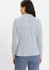 Gestreepte blazer in wit en marineblauw, met een getailleerde pasvorm, reverskraag en lange mouwen. Soepele textuur met subtiele details.