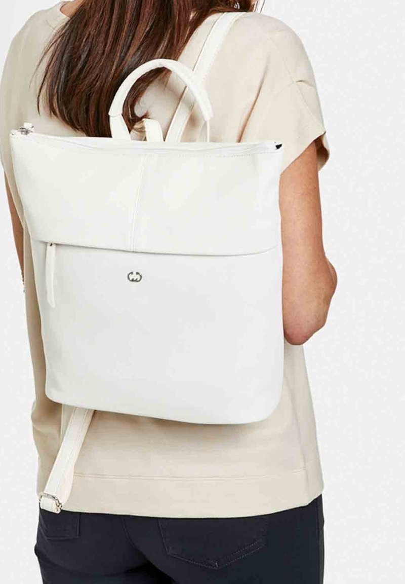 White, minimalist backpack made of smooth material with a top handle, adjustable straps, and a front zipper pocket. Subtle logo detail.