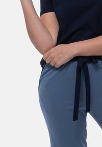 Marinblå t-shirt med korta ärmar ihop med ljusblå joggerbyxor som har bindeband i midjan, mjukt tyg och sidfickor.