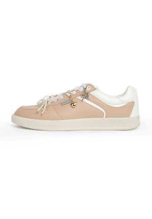 Sneaker beige e bianca con lacci bianchi, ciondoli a forma di cuore in perla e oro e un ciondolo a forma di fiocco metallico sul lato.