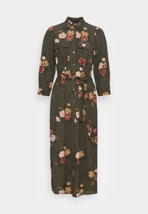 Robe verte olive à manches longues avec une patte de boutonnage devant, imprimé floral rose, jaune et rouge, poches poitrine et ceinture à nouer à la taille.