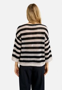 Schwarz-weißer gestreifter Häkelpullover mit lockerer Passform, drei Viertel Ärmeln und offener Maschenstruktur.