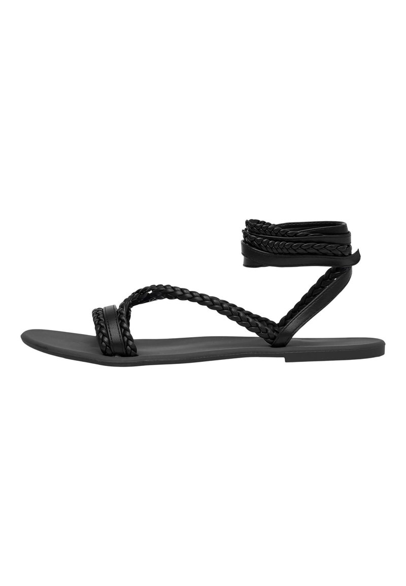 Sandali neri piatti con strappi intrecciati, caratterizzati da un design avvolgente per la caviglia. Realizzati in materiale sintetico con una texture liscia.