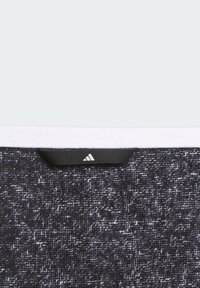 Czarna tkanina o teksturze z delikatnym wzorem, z czarną metką logo u góry. Zwężający się kształt z miękkim, zużytym wyglądem.