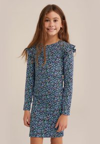 Modra cvetna obleka z dolgimi rokavi in nabranimi ramenimi detajli, ki ima mešanico belih, vijoličnih in zelenih vzorcev na raztegljivem materialu.