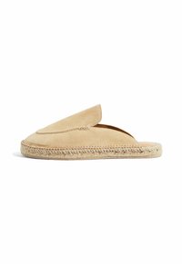 Scarpe slip-on in suede beige con punta tonda e suola in juta intrecciata, caratterizzate da un bordo superiore non strutturato e dettagli di cucitura minimi.