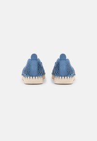 Blaue, durchbrochene Slipper mit strukturiertem Design, beiger flexibler Sohle und kontrastierendem blauen Besatz. Verfügt über eine Schlaufe an der Ferse zum leichteren Anziehen.
