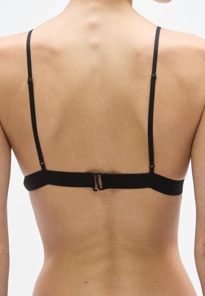 Μαύρο σουτιέν με ρυθμιζόμενους ιμάντες, μινιμαλιστικό σχέδιο, λεία υφή, με κλείσιμο με γάντζο στο πίσω μέρος, χωρίς διακοσμήσεις.