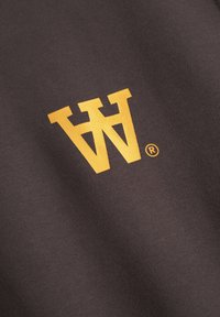 Brown fabric with a subtle texture featuring a large yellow "W" logo and a registered trademark symbol in the bottom right corner.