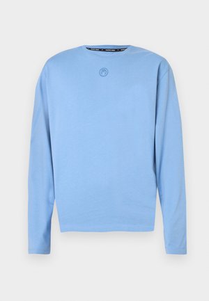 Helevarrukaga särk helesinisest pehmest puuvillast. Omab ümarsuu kaela ja väikest rinnal tikitud logo. Sirge äärega.