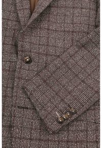 Brown patterned blazer fabric with a textured weave, featuring a notched lapel and four dark buttons on the cuff.
