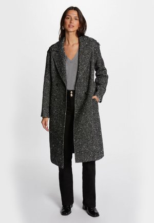 Cappotto doppiopetto realizzato in tessuto testurizzato nero e grigio. Presenta un ampio colletto, tasche laterali e arriva fino a metà coscia.