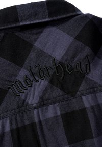 Camicia di flanella a scacchi nera e viola con colletto. Presenta la scritta "Motörhead" ricamata in nero sul retro. Tessuto morbido e testurizzato.