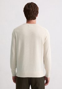 Sweter w kolorze kremowym, lekki miks wełny, okrągły dekolt, ściągacze przy mankietach i u dołu, o gładkiej fakturze i prostym designie.