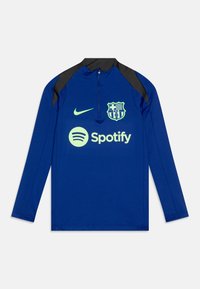 Blå langermet jersey med svarte detaljer, kvart glidelås, Nike-logo og Barcelona-merke. Har grønn Spotify-logo på forsiden.