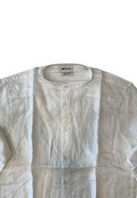 Camicia bianca in lino con scollatura rotonda, chiusura con bottoni e maniche corte. Presenta un tessuto leggermente texture e un'etichetta di vestibilità regolare.